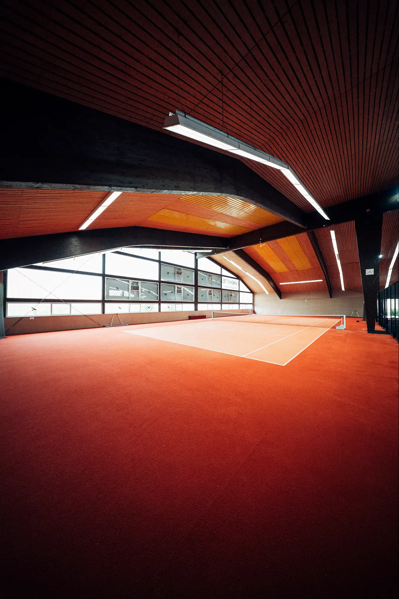 Tennis-Court mit orangefarbenem Boden in der Halle